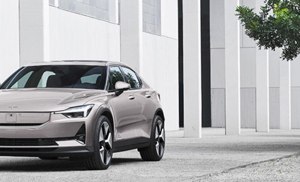 Polestar 2 in lifestyle shot next to a tree on a forecourt