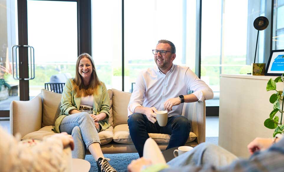 two colleagues sitting on the sofa chatting