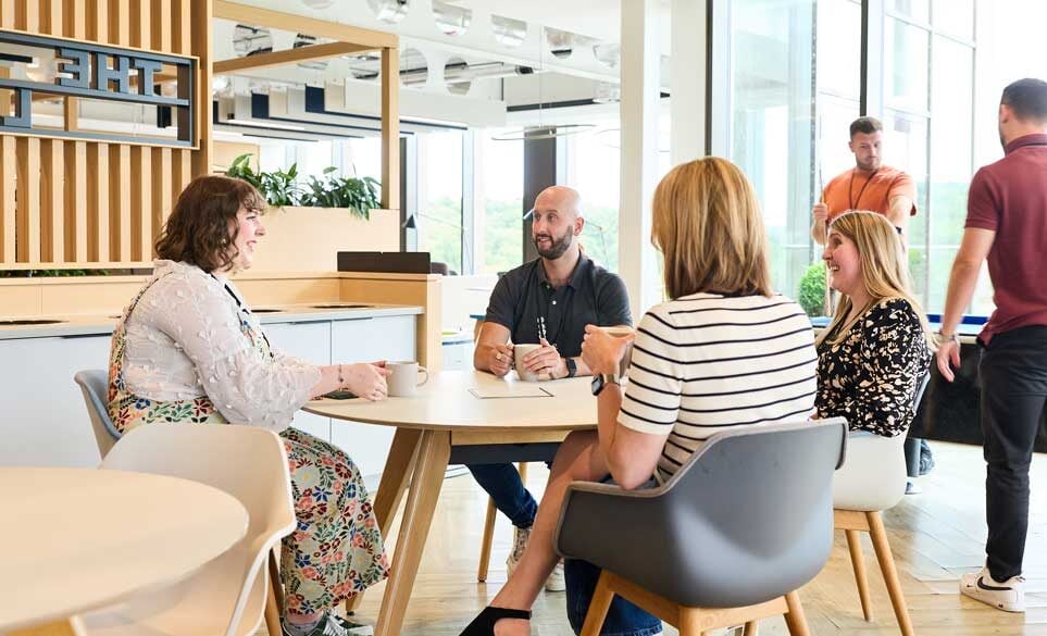 Staff around a table chatting